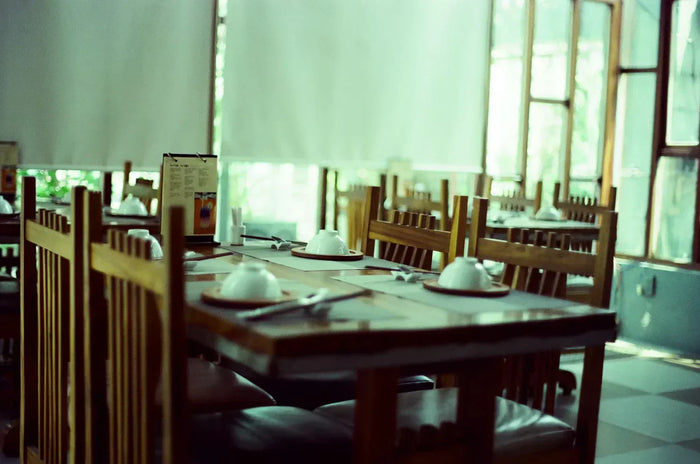 Medium shot in a diner of an empty wooden restaurant table with menus and plates turned over.