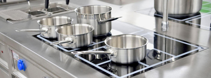 A clean commercial range with clean stainless steel pots