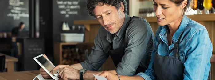 Two restaurant staff computing operation expenses 