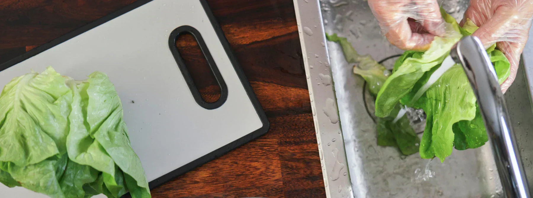Food handler wearing gloves washing fresh lettuce in a commercial kitchen sink beside a cutting board during food preparation.