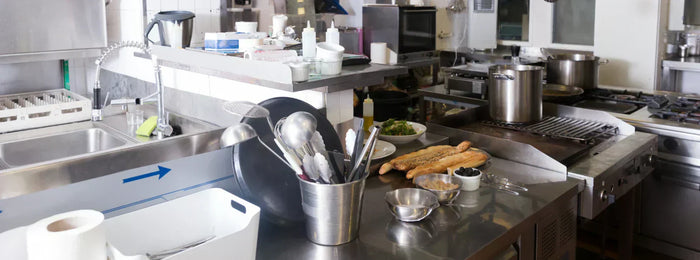 A cafe kitchen equipped with pots, pans, ovens, and other cafe equipment