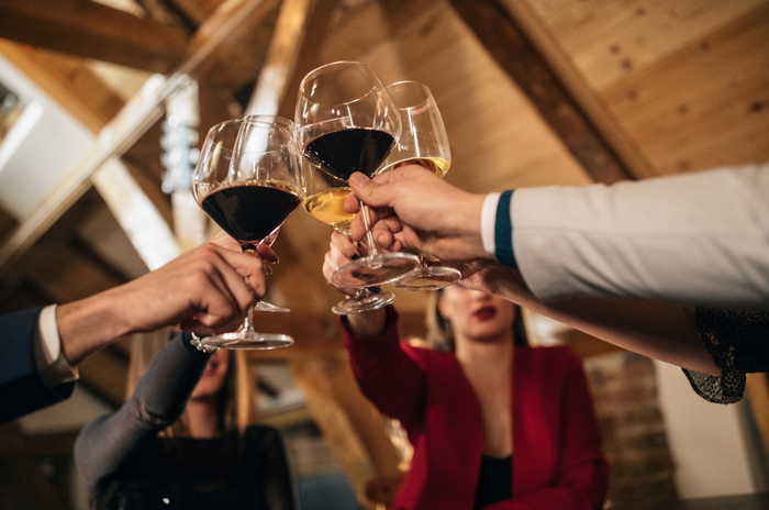 A group of friends toasting their wine glasses at a winery