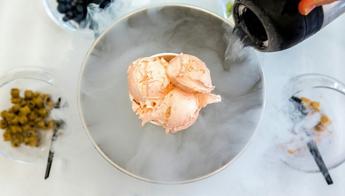 Pouring liquid nitrogen into a bowl to create instant ice cream, a unique element for an immersive restaurant experience