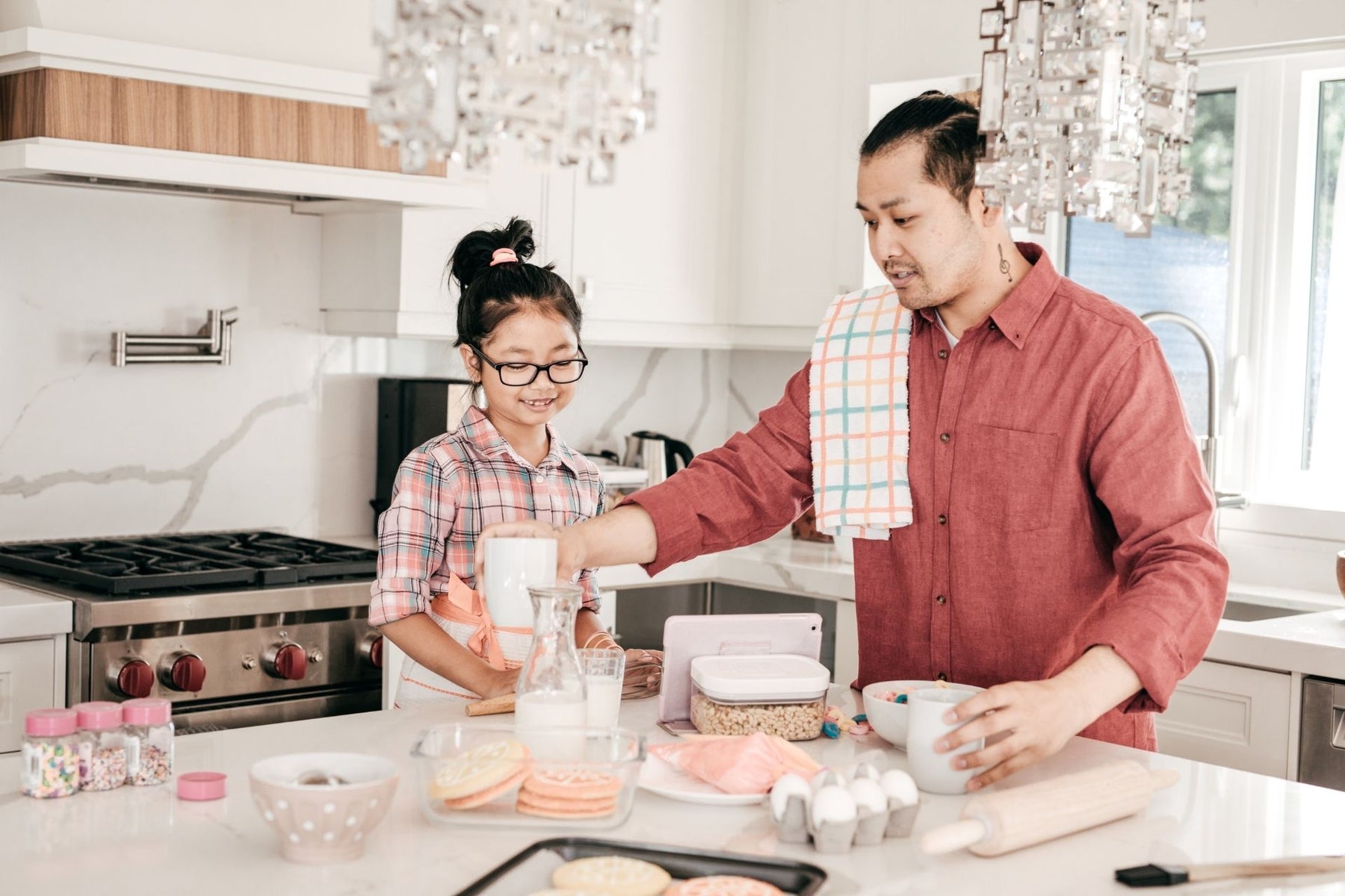 A father and daughter baking cookies in a kitchen 