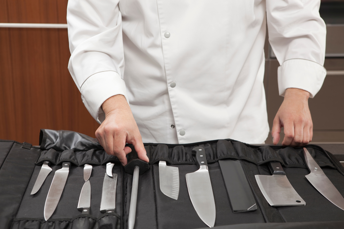 A chef’s knife set laid out in front of a cook