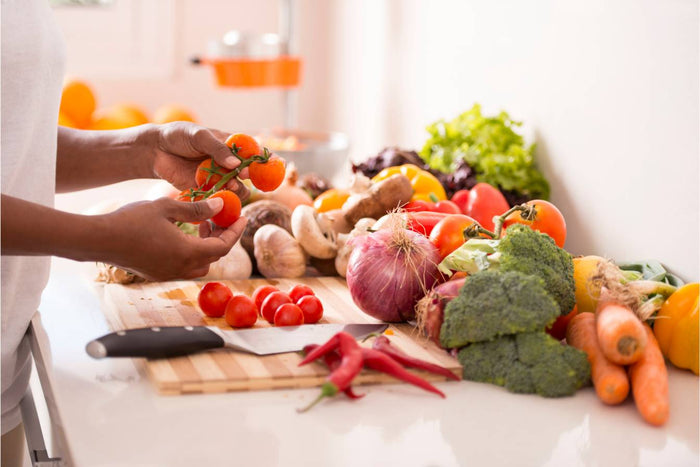Various fruits, vegetables, nuts, and dairy products on a wooden cutting board
