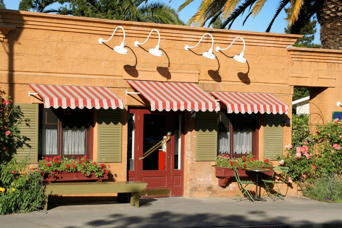 The exterior of a French bistro with red and white striped awnings