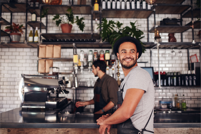 A happy coffee shop owner appreciating his newly opened cafe