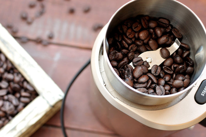 Coffee beans placed inside an electric coffee grinder