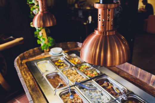 Several ingredients at a make-your-own bar under a heat lamp