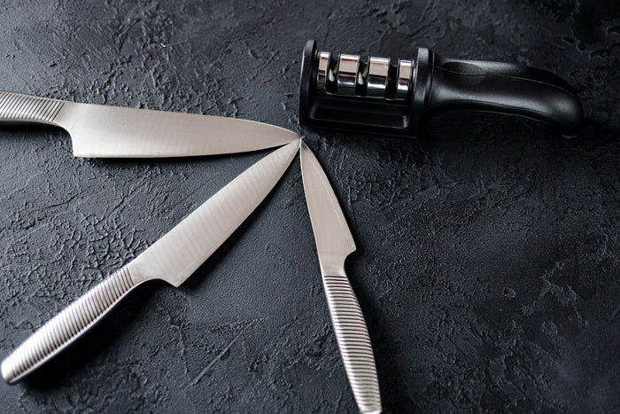 Three knives and a manual knife sharpener 