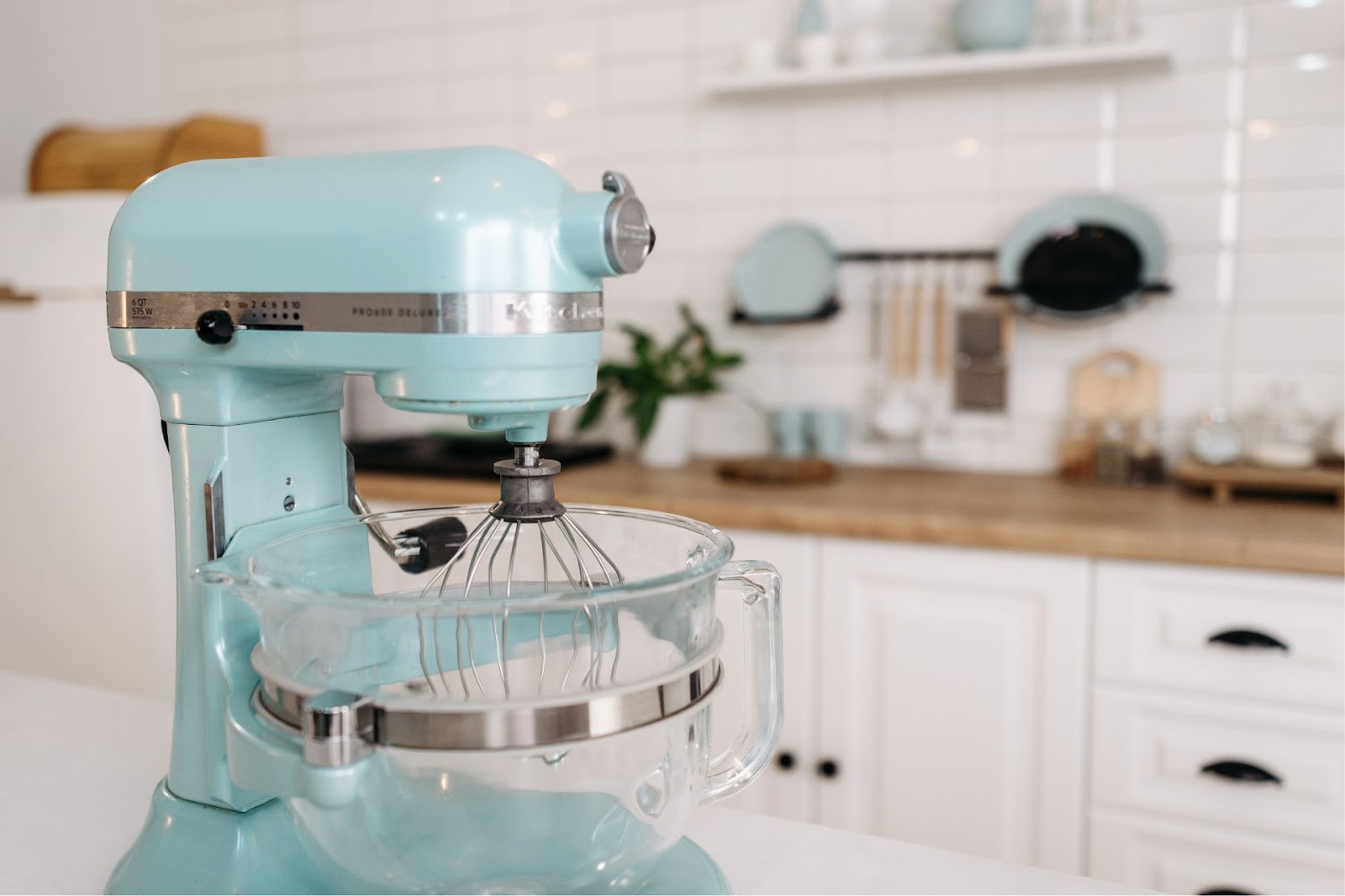 A light blue stand mixer on a white kitchen counter 