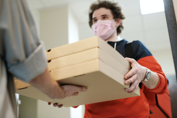 Delivery man handing over food boxes