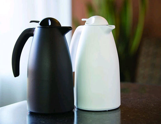 Service Ideas ALPH10WH Durable White Plastic Exterior 1L Alpha Carafe on table beside black carafe